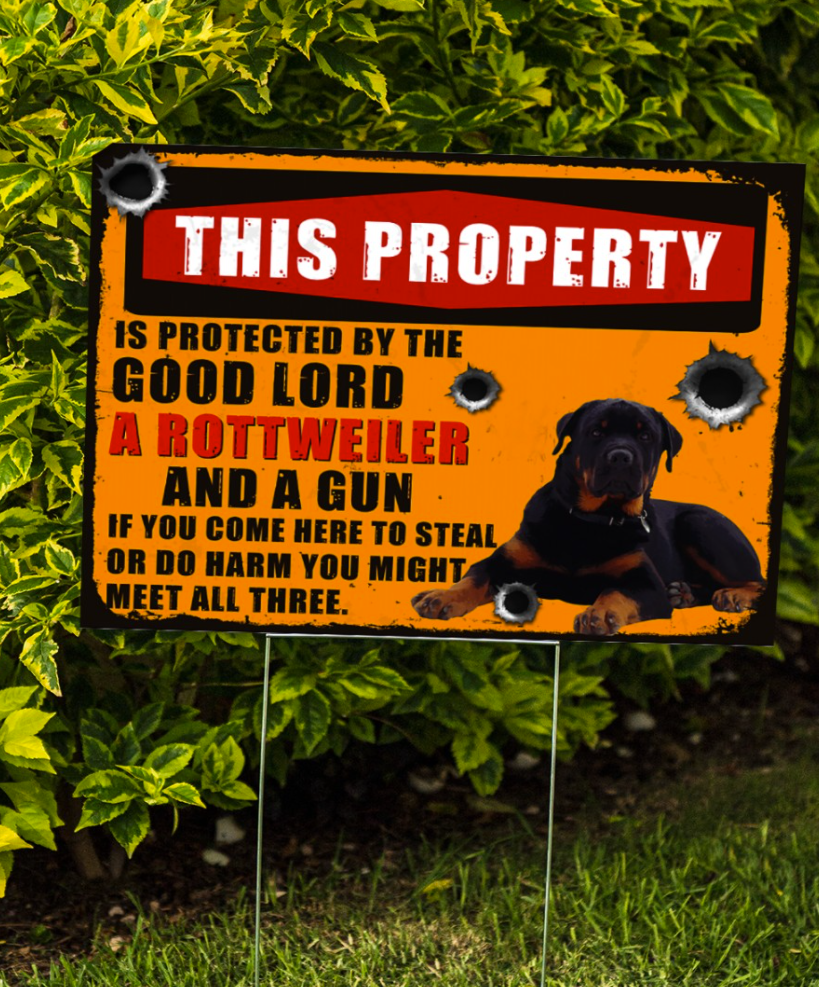 This property is protected by the good lord a rottweiler and a gun yard sign