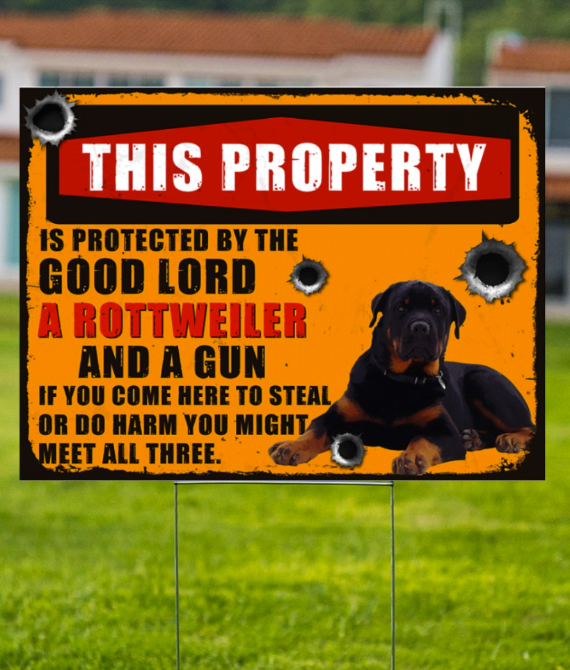 This property is protected by the good lord a rottweiler and a gun yard sign